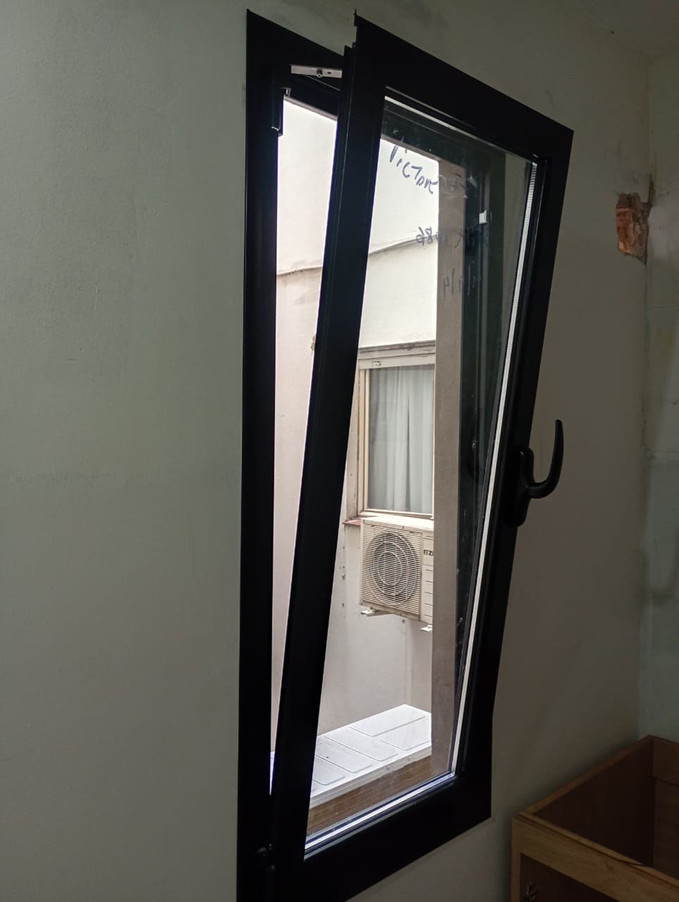 Ventana oscilobatiente negra inclinada para ventilar