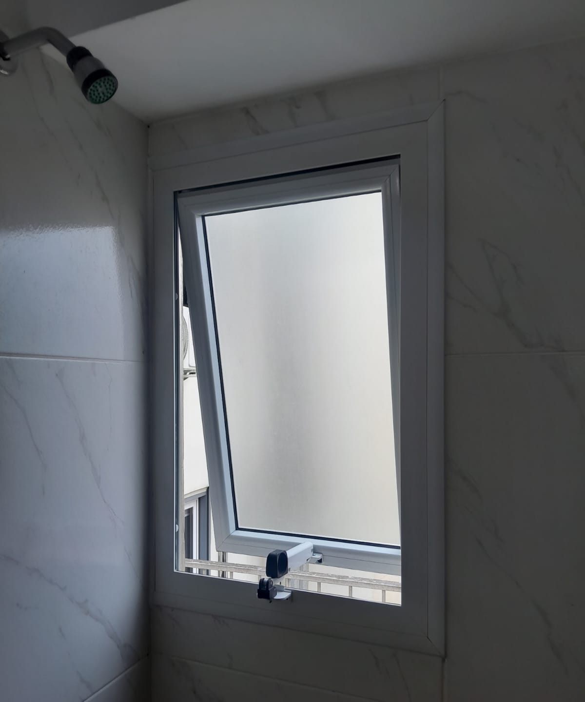 Ventiluz blanco con vidrio esmerilado en un baño